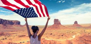 woman holding usa flag in desert