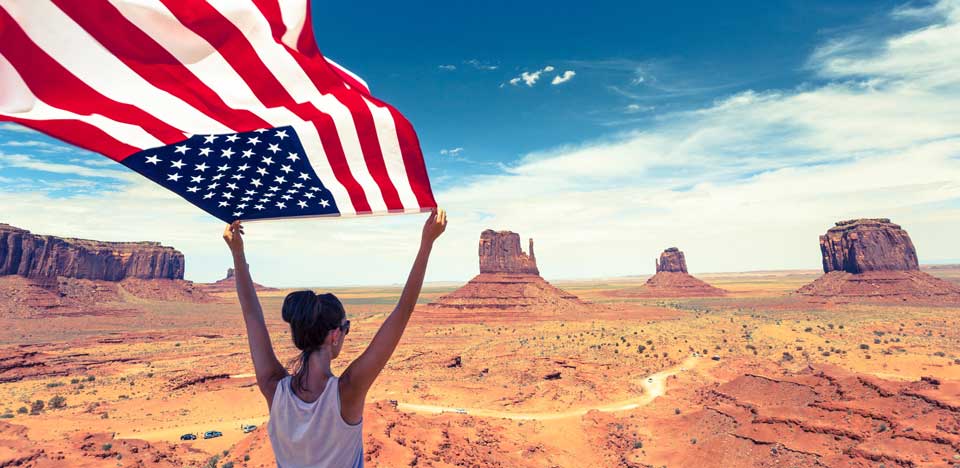 woman holding usa flag in desert