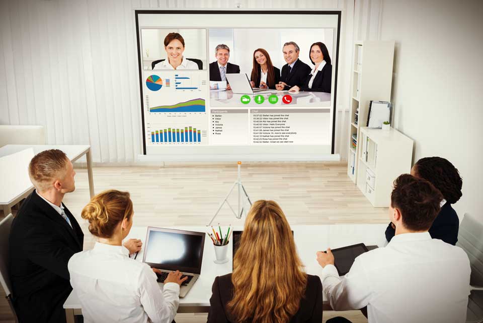 remote team meeting in front of large screen