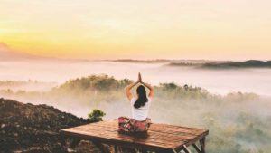 Woman doing a yoga pose on mountain top