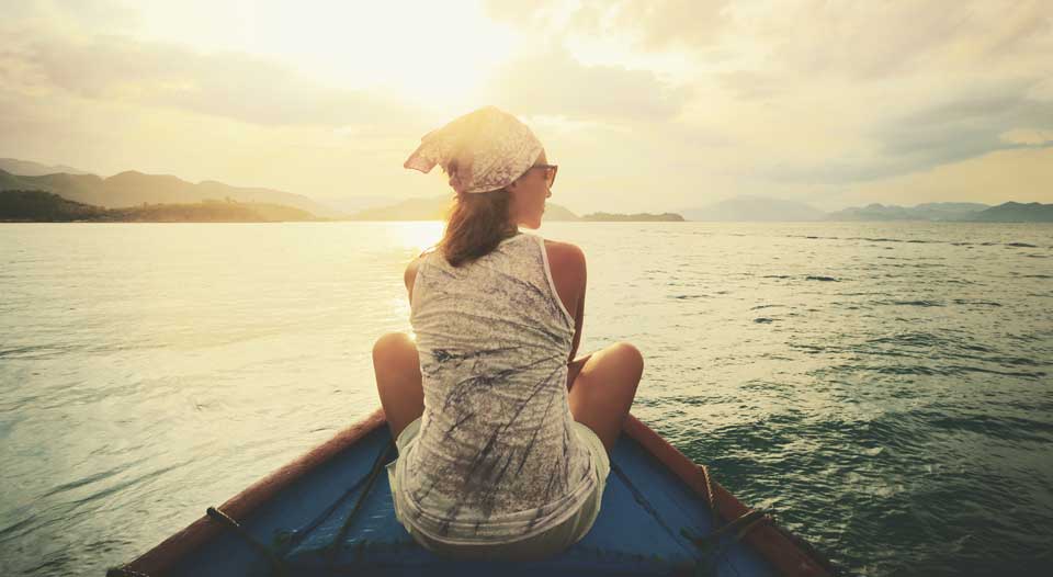 Woman on a boat contemplating body of water