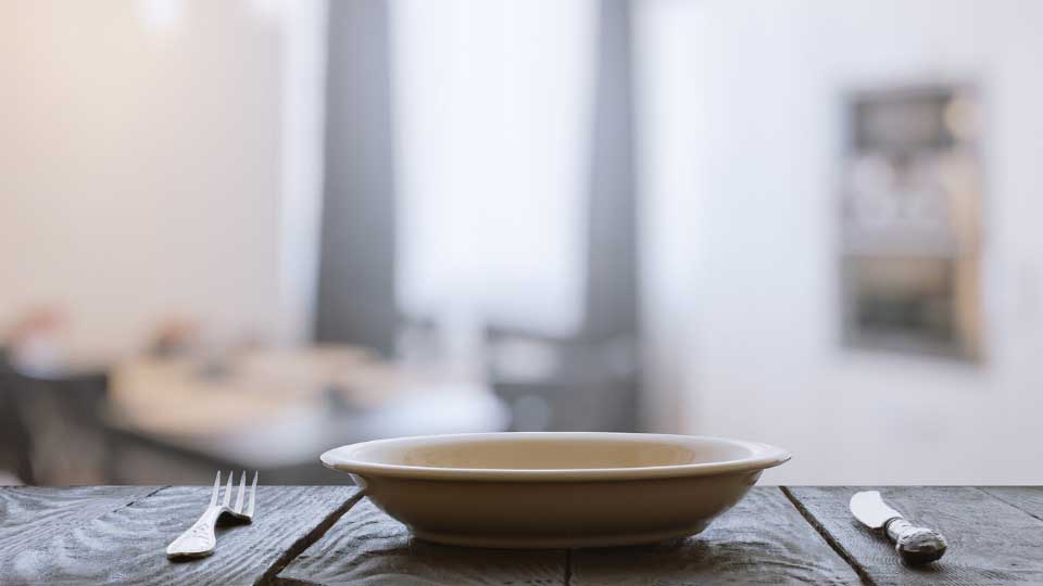 empty plate with fork and knife on wooden table