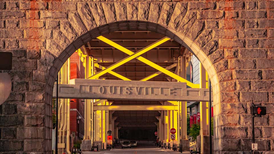 Sign "Louisville" under a bridge with sunny background