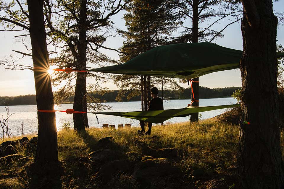 man in a red shirt in a hamac looking at a lake