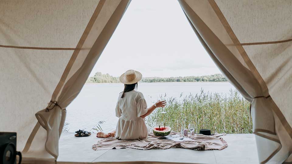 1. woman with white dress under a tent looking at a lake