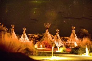 4. tipi tents with campfire in the background