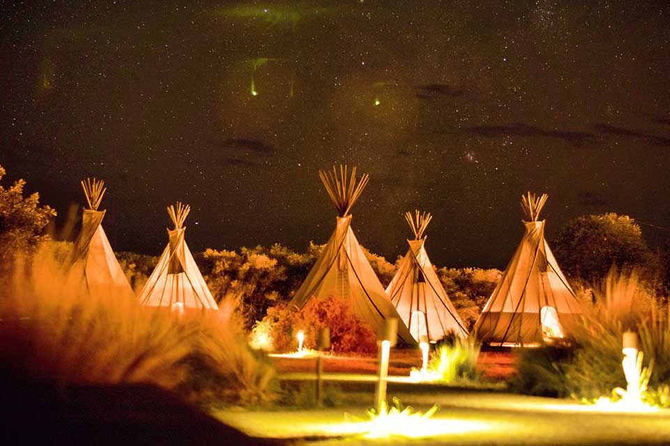 4. tipi tents with campfire in the background