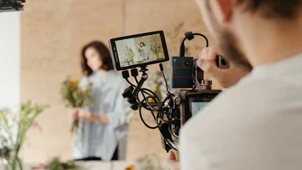 man filming holding camera