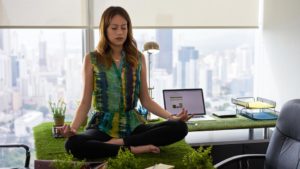 A person sitting on a desk meditating