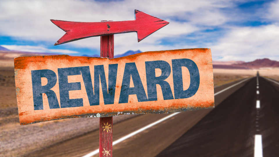 A picture containing an incentive travel sign with an arrow with the word Reward